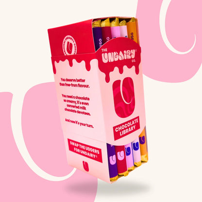 A box labelled The Udairy Co. Chocolate Library containing several colourful chocolate bars, including the Fruit & Nut bar and the Original Creamy bar, with stylised branding and text on the packaging.