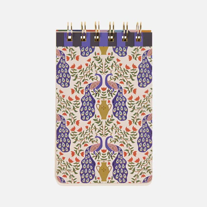 A spiral-bound Peacock Flip Notebook with a patterned cover showcasing blue and gold peacocks and colourful floral designs on a light background—ideal creative stationery for your desk.