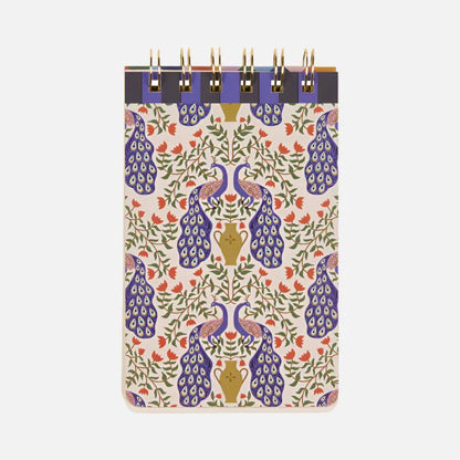 A spiral-bound Peacock Flip Notebook with a patterned cover showcasing blue and gold peacocks and colourful floral designs on a light background—ideal creative stationery for your desk.