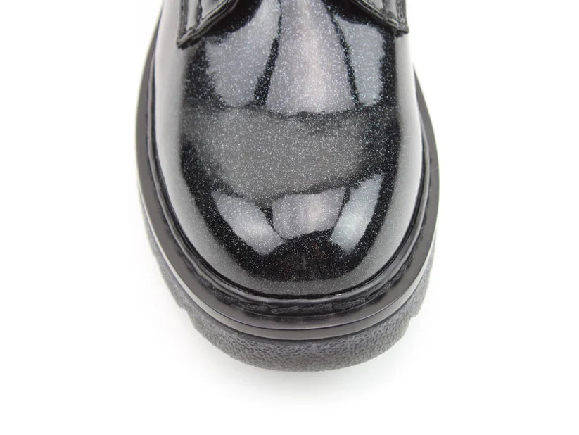 Close-up view of the toe area of a shiny black shoe with a textured black sole, visible reflections on the surface, and comfortable memory foam insoles.