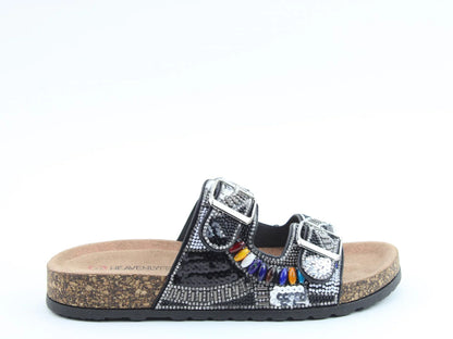 A black slip-on sandal featuring two silver buckles, decorative beads, sequins, a cork sole and a contoured footbed. Crafted from vegan-friendly materials for stylish comfort.