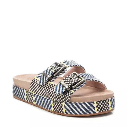 A pair of double buckle sandals with a platform sole, featuring woven, multicoloured geometric patterns, two adjustable buckle straps, and a cushioned footbed.
