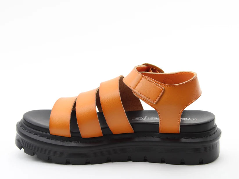 Orange leather summer sandal with three wide straps and a Velcro ankle strap, featuring a thick, black, rugged sole—perfect lightweight sandals for sunny days. Rewritten in British English: Orange leather summer sandal with three broad straps and a Velcro fastening at the ankle, featuring a thick, black, rugged sole—ideal lightweight sandals for sunny days.