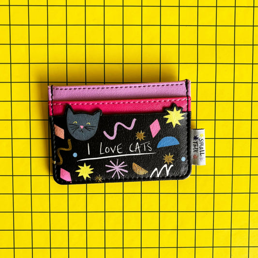 A compact PVC cat card holder in black and pink, featuring playful patterns, a cat illustration, and “I LOVE CATS” text, set against a yellow chequered background—ideal as a present for cat lovers.