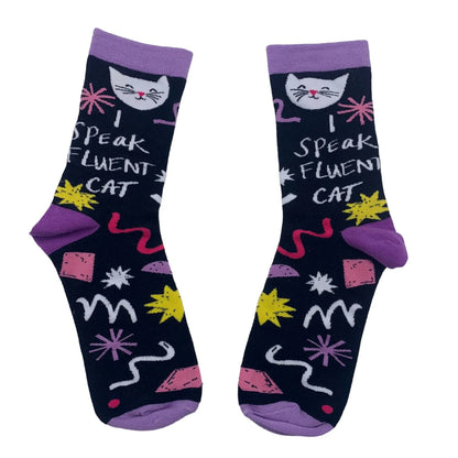 A pair of black bamboo socks with purple toes and cuffs, adorned with cat faces, colourful shapes, and the text I SPEAK FLUENT CAT—a perfect gift for any cat lover.