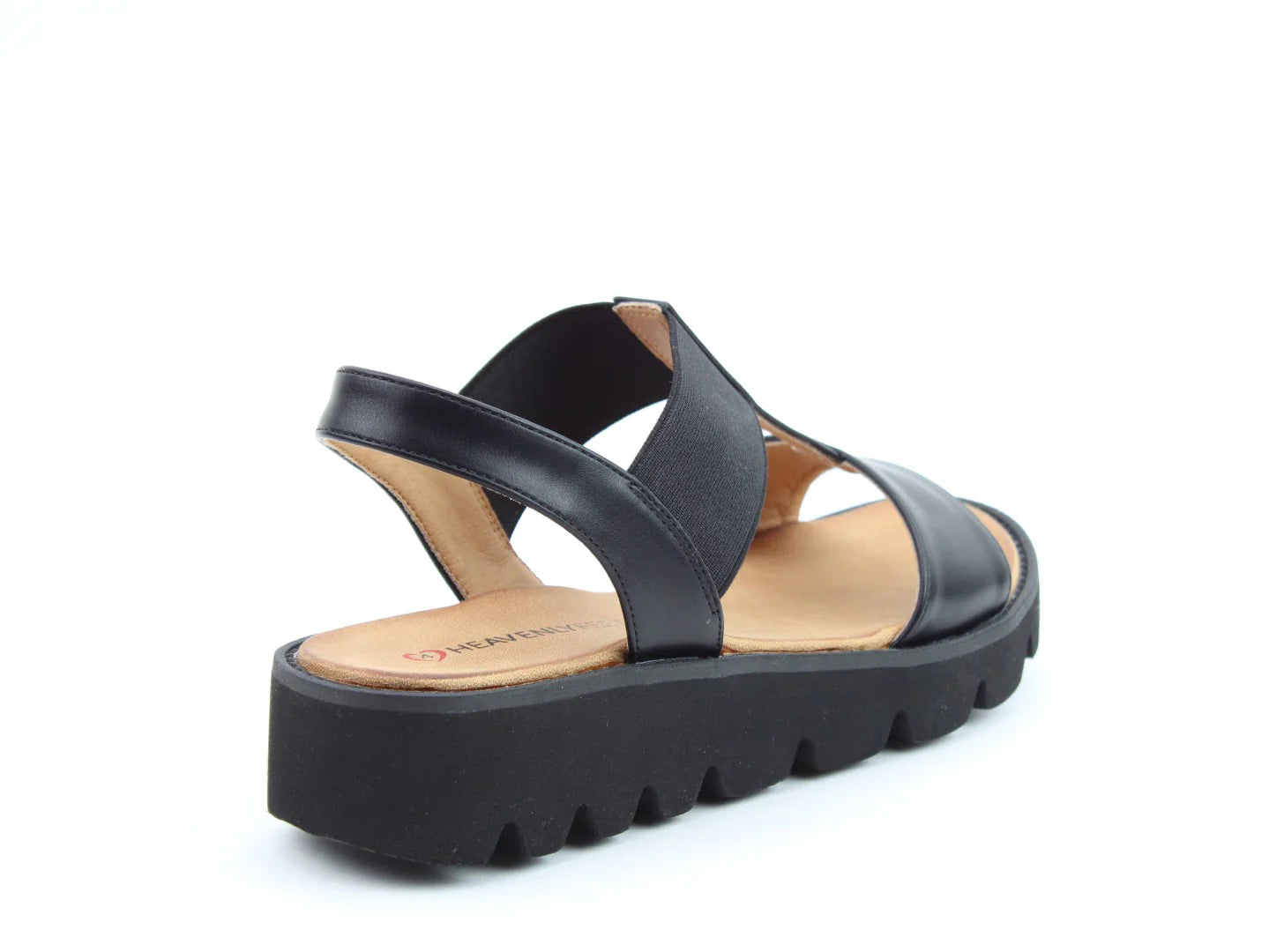 The Ritz Casual Sandals feature a black design with a thick, grooved sole and criss-cross straps, all crafted from vegan-friendly materials. The tan insole includes a cushioned footbed for added comfort on a white background.