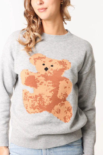A person wearing a cosy grey jumper with a large pixelated teddy bear graphic on the front.
