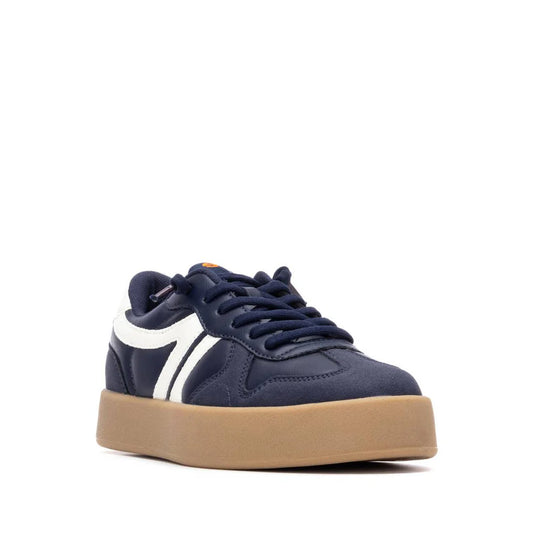 Navy blue vegan trainers with white side stripes, navy laces, and a thick tan gum sole. These PETA-approved, non-slip trainers are displayed at an angle against a white background.