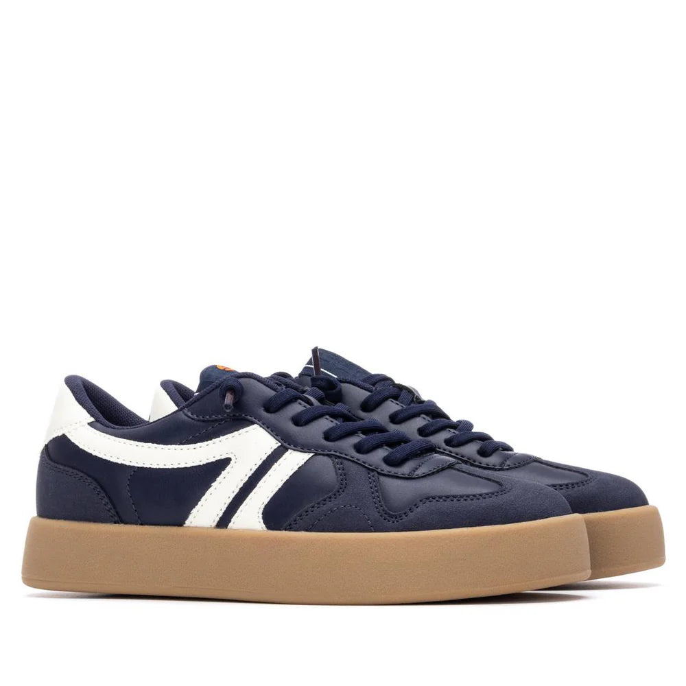 A pair of navy blue vegan trainers with white detailing and tan rubber soles, positioned side by side on a white background.