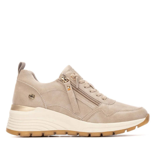 Beige and gold vegan trainers featuring a chunky white and tan sole, side zip, lace-up front, subtle logo on the side, removable insoles, and made with PETA-certified vegan materials.
