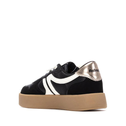 A black trainer featuring a white wavy stripe, white laces, a tan sole, and metallic heel detail marked Refresh—stylish vegan trainers that make an impression.