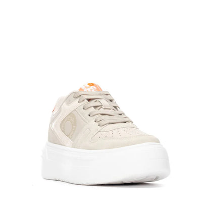 Beige vegan trainers with a chunky white sole, removable insole, beige laces, and orange logo accents on the tongue and side, seen from the front.
